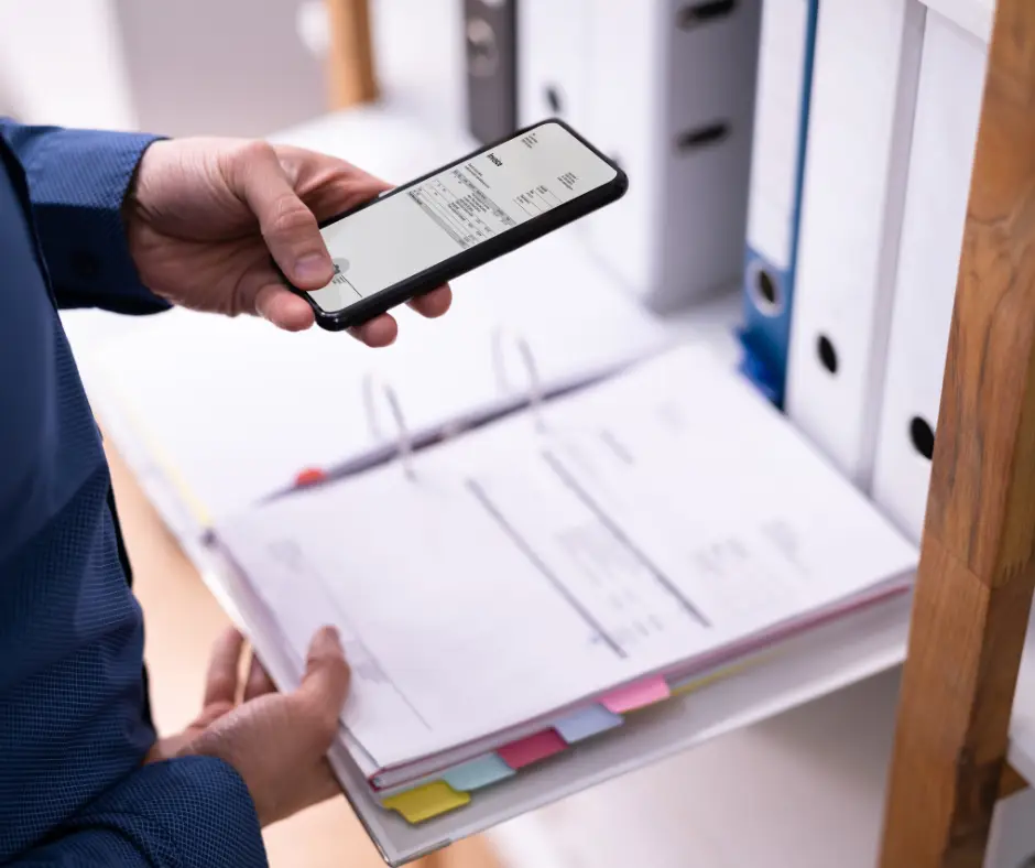 a person holding a phone and a binder